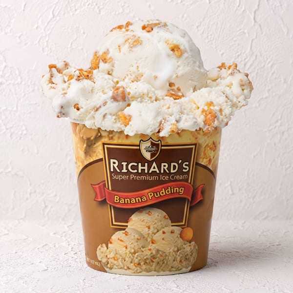 A pint of Richard's Banana Pudding ice cream, overflowing with scoops and crunchy bits.