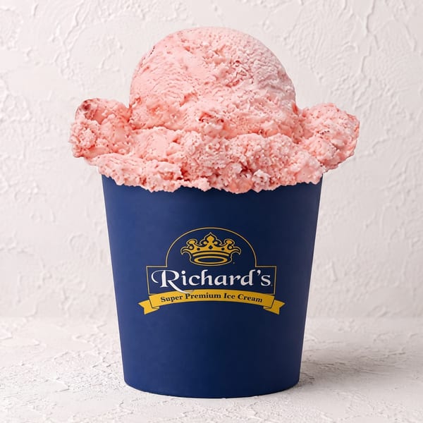 A large scoop of pink strawberry ice cream overflowing from a blue Richard's Super Premium Ice Cream cup.